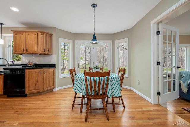 dining room with a wealth of natural light and light wood-style floors