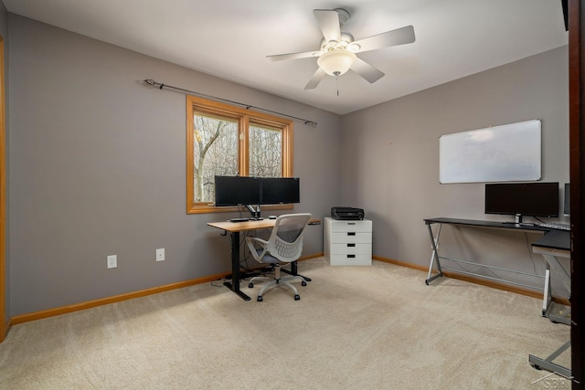 carpeted home office featuring baseboards and a ceiling fan