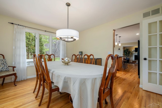 dining room with light wood-type flooring and visible vents