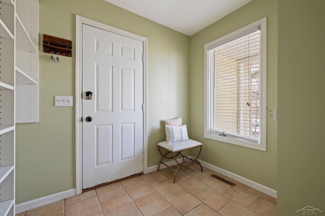 sitting room with baseboards, a wealth of natural light, and visible vents