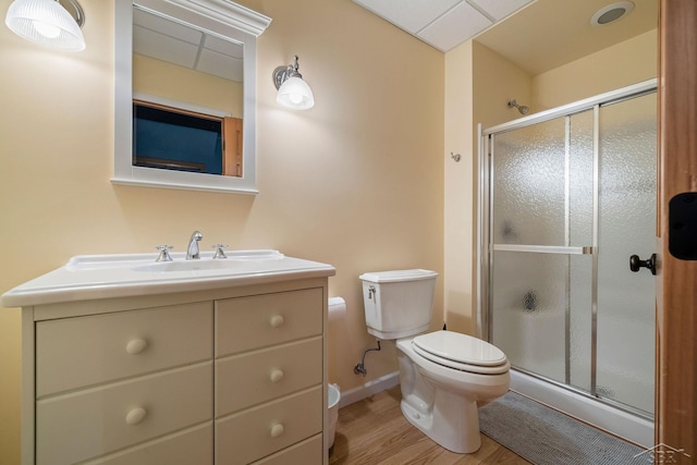 full bathroom with toilet, a shower stall, wood finished floors, and vanity