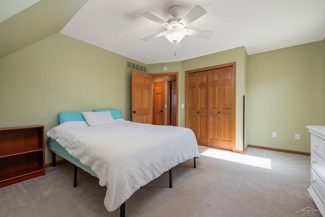 bedroom with a closet, ceiling fan, light colored carpet, and visible vents