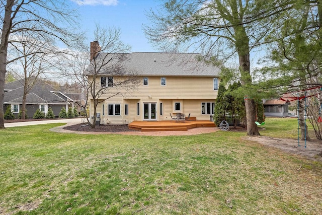 back of house featuring a wooden deck, a yard, and a chimney