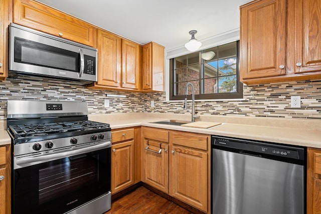 kitchen with a sink, light countertops, decorative backsplash, and stainless steel appliances