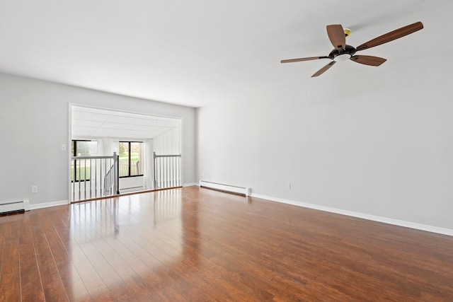 spare room featuring ceiling fan, baseboard heating, wood finished floors, baseboards, and a baseboard radiator