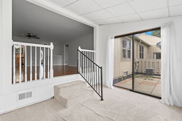 interior space with visible vents, baseboards, a paneled ceiling, a ceiling fan, and carpet