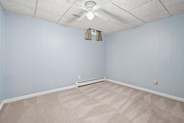 unfurnished room featuring ceiling fan, a baseboard heating unit, carpet flooring, and a paneled ceiling