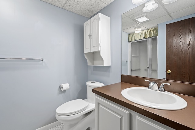bathroom with an enclosed shower, toilet, a drop ceiling, and vanity