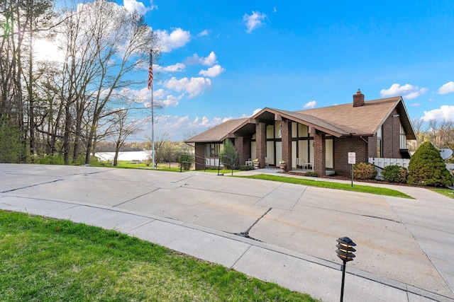 view of front of property featuring brick siding and a chimney