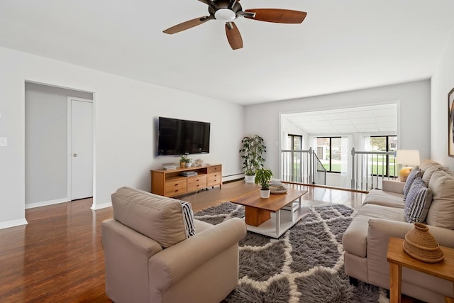 living room featuring baseboards, ceiling fan, wood finished floors, and a baseboard radiator