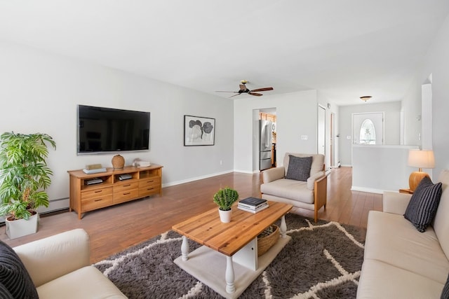 living area featuring baseboards, ceiling fan, and wood finished floors