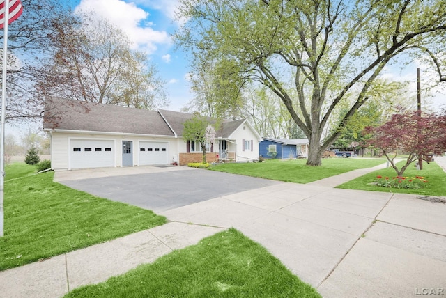 single story home featuring a garage, a front lawn, and concrete driveway