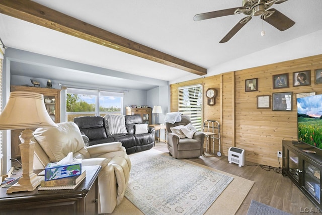 living area featuring a ceiling fan, wood finished floors, wooden walls, and beamed ceiling