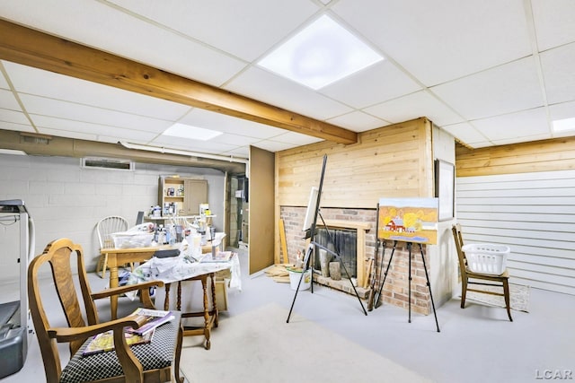 interior space featuring concrete block wall, wood walls, and a paneled ceiling