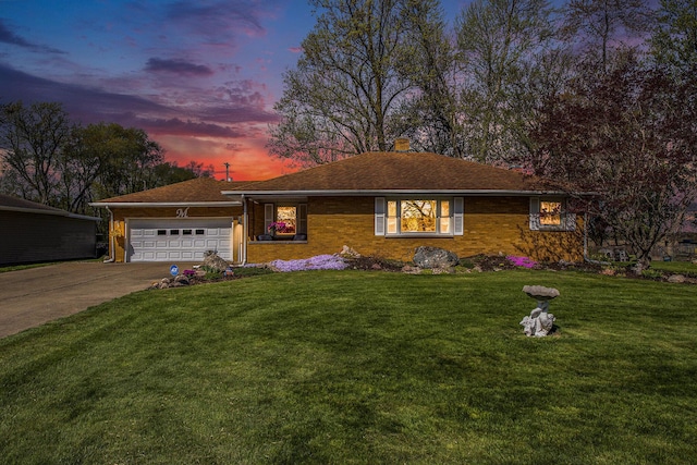 ranch-style house with an attached garage, a yard, driveway, and brick siding