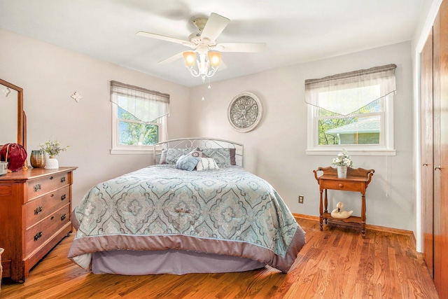 bedroom with a ceiling fan, baseboards, and wood finished floors