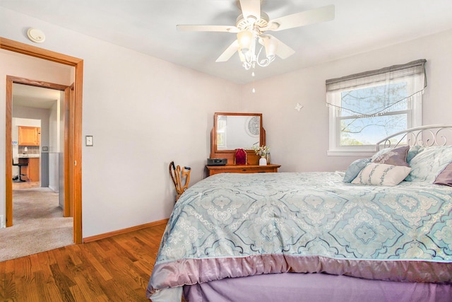 bedroom with baseboards, ceiling fan, and wood finished floors