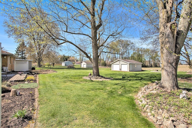 view of yard featuring a detached garage and an outbuilding