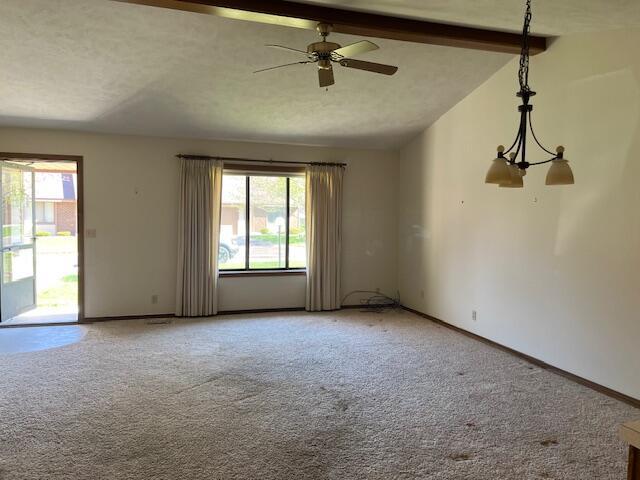 unfurnished room with lofted ceiling with beams, a healthy amount of sunlight, and light carpet
