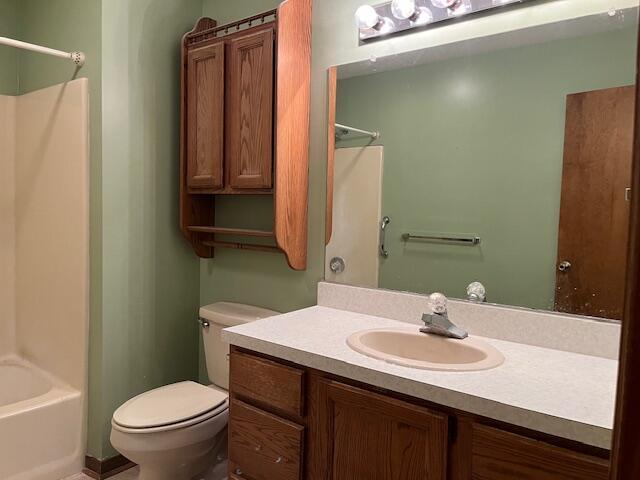 bathroom with vanity, shower / bathtub combination, and toilet