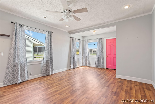 empty room with a ceiling fan, a textured ceiling, and wood finished floors