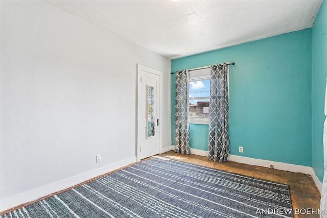 empty room with baseboards and wood finished floors