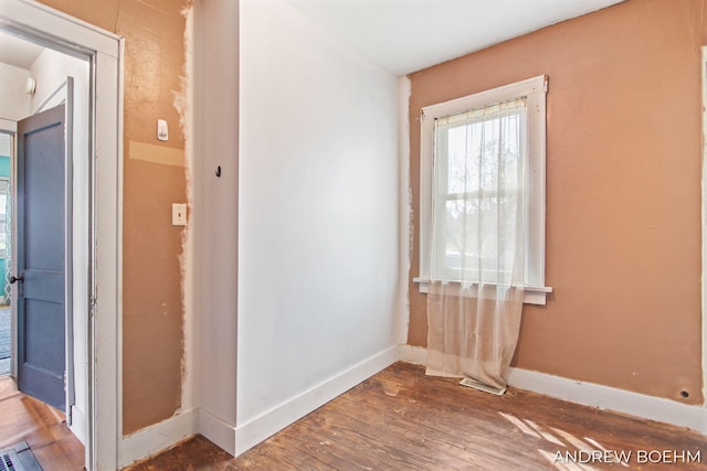 unfurnished room featuring baseboards and wood finished floors