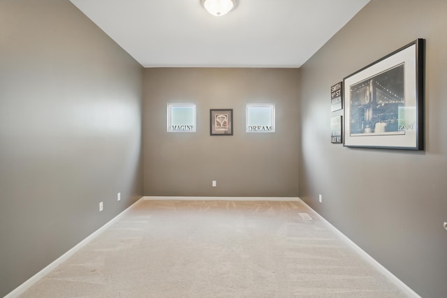 carpeted empty room featuring baseboards