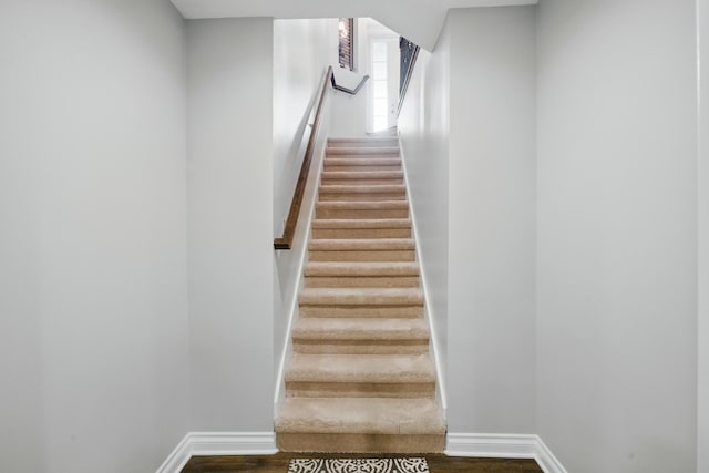 stairway featuring baseboards and wood finished floors