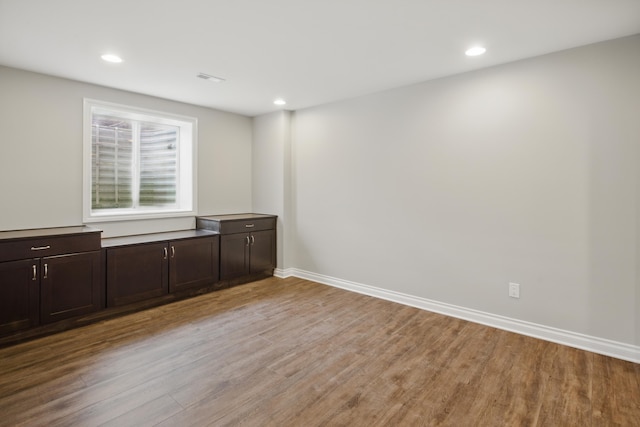 spare room with recessed lighting, light wood finished floors, and baseboards