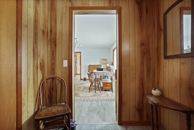 entryway featuring wooden walls, arched walkways, and wood finished floors