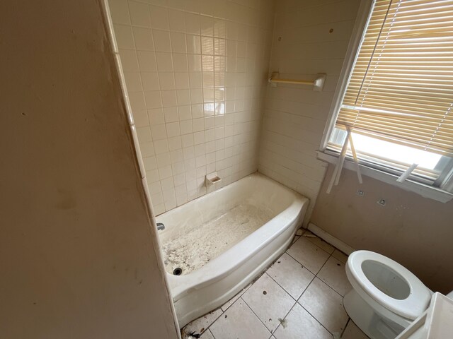 bathroom featuring tile patterned flooring, baseboards, and toilet