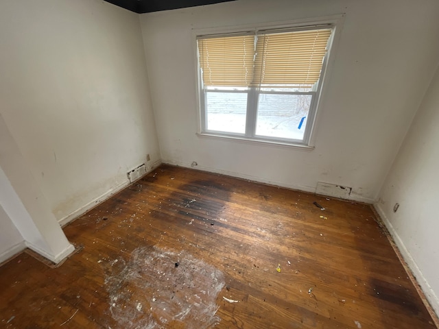 unfurnished room with wood-type flooring and baseboards