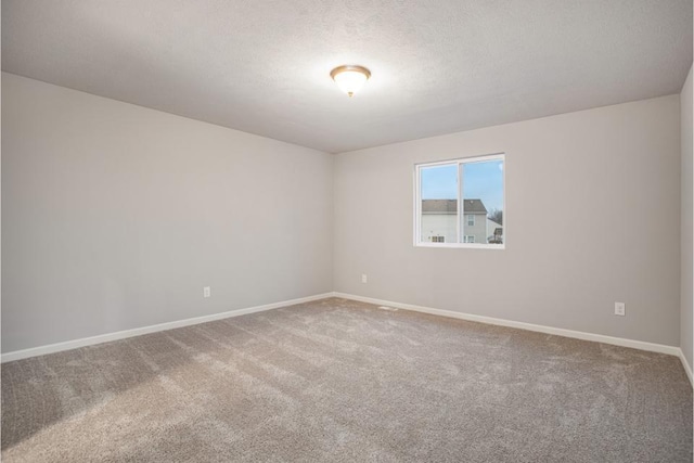unfurnished room with baseboards, carpet flooring, and a textured ceiling