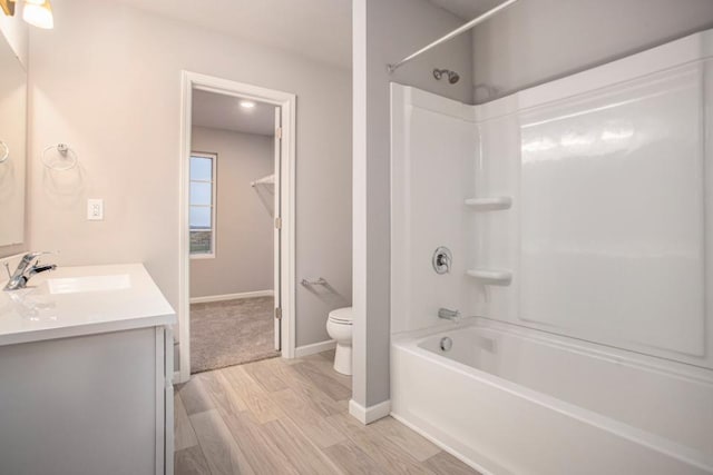 full bathroom with wood finished floors, vanity, baseboards, toilet, and bathing tub / shower combination