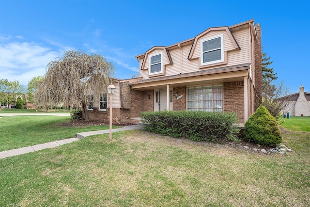 traditional home featuring a front lawn and brick siding