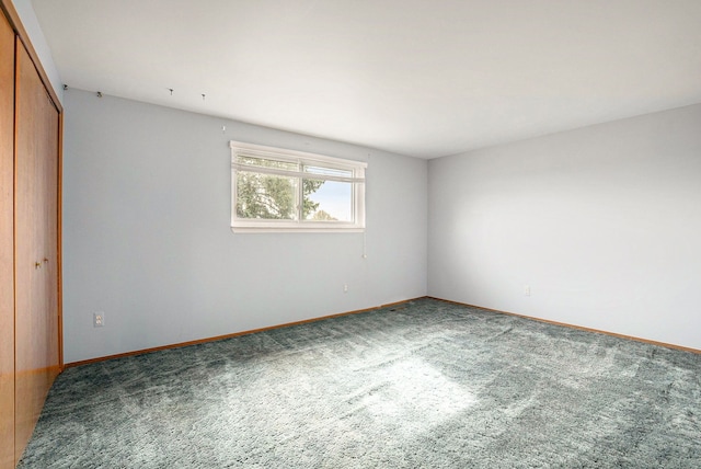 unfurnished bedroom featuring carpet floors, baseboards, and a closet