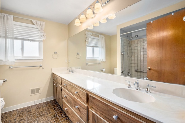 full bathroom with toilet, baseboards, visible vents, and a sink