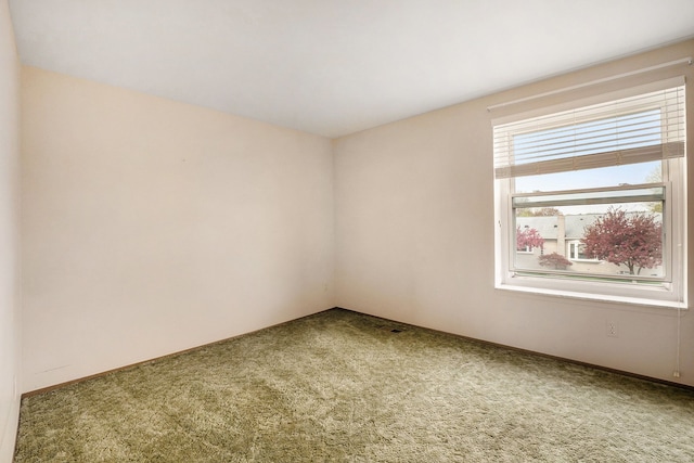 carpeted empty room featuring baseboards