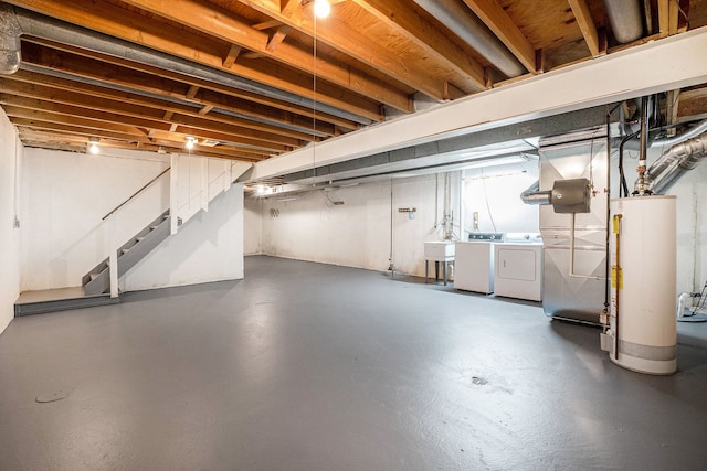 unfinished below grade area featuring separate washer and dryer, a sink, stairs, and gas water heater