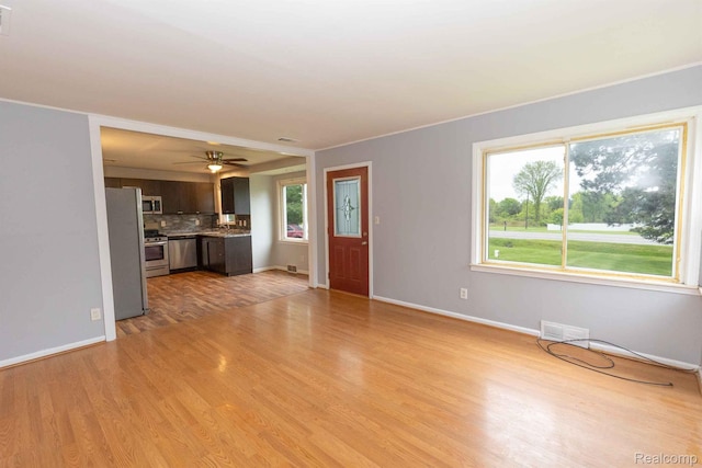968 N Wilder Rd, Lapeer, MI 48446 - unfurnished living room featuring light wood finished floors, baseboards, and a ceiling fan