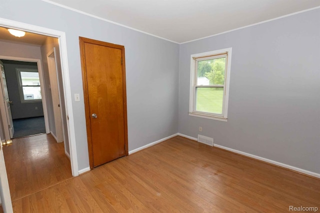 968 N Wilder Rd, Lapeer, MI 48446 - empty room with light wood finished floors, healthy amount of natural light, baseboards, and crown molding