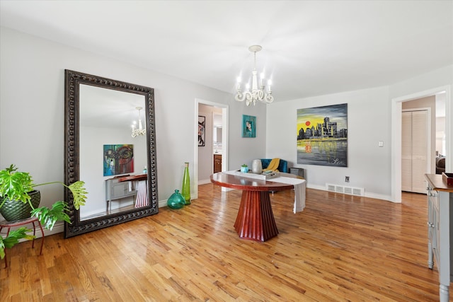 dining space featuring an inviting chandelier, light wood-style flooring, baseboards, and visible vents