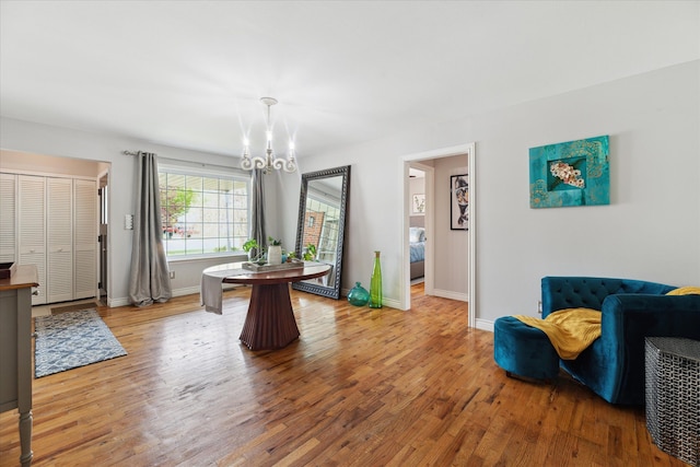 dining area with baseboards, a chandelier, and wood finished floors