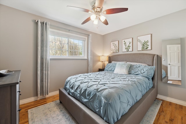 bedroom with baseboards, ceiling fan, and wood finished floors