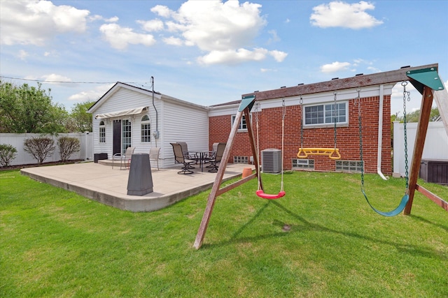 back of property with a lawn, brick siding, a fenced backyard, and a patio area