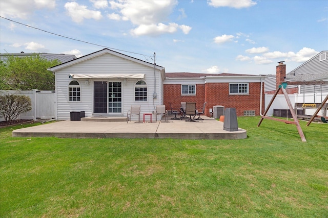back of house with fence, brick siding, cooling unit, a lawn, and a patio