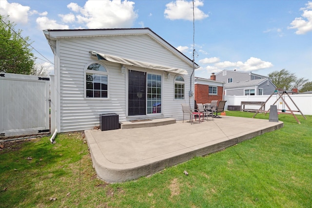 rear view of property with a lawn, fence, and a patio area