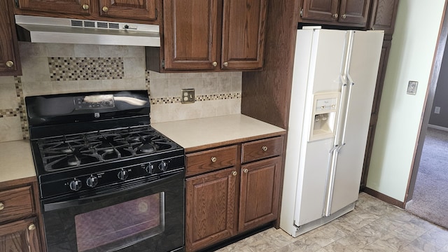 kitchen with decorative backsplash, light countertops, black gas range, white fridge with ice dispenser, and under cabinet range hood