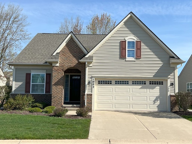 1082 Paddock Dr Unit 78, South Lyon, MI 48178 - traditional-style house featuring brick siding, a shingled roof, an attached garage, and concrete driveway